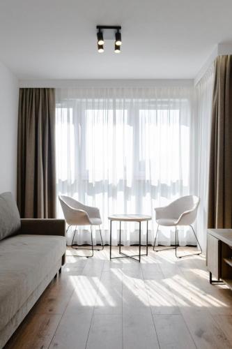 a living room with a couch and chairs and a table at Apartament pod Szyndzielnią Enduro&Ski #nestapartamenty in Bielsko-Biała
