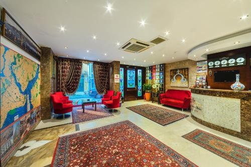 a living room with red chairs and a map of the world at The Magnaura Palace Hotel in Istanbul