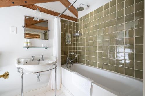 a bathroom with a sink and a bath tub at Honeycrisp Barn in Newquay