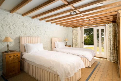 een slaapkamer met 2 bedden en een raam bij Honeycrisp Barn in Newquay