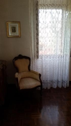 a chair sitting in front of a window at Villa Storica Calderino in Monte San Pietro