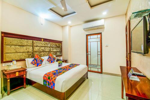 Dormitorio con cama, escritorio y TV en FabHotel Eleven Heights en Bhopal