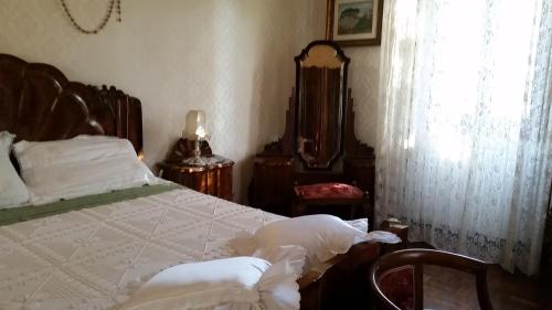 a bedroom with a large bed and a mirror at Villa Storica Calderino in Monte San Pietro