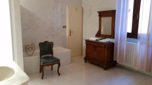 a bathroom with a chair and a sink and a tub at Villa Storica Calderino in Monte San Pietro