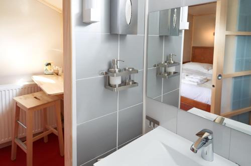 a bathroom with a sink and a mirror at Péniche Daphné's in Auvers-sur-Oise