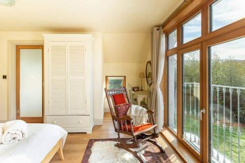 a bedroom with a bed and a large window at Kenmare Eco Lodge in Kenmare