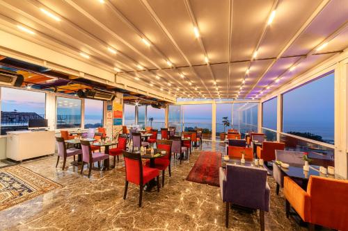 a restaurant with tables and chairs and large windows at The Magnaura Palace Hotel in Istanbul