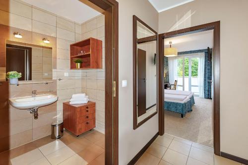 a bathroom with a sink and a mirror at VacationClub – Aquarius Apartament 99 in Kołobrzeg