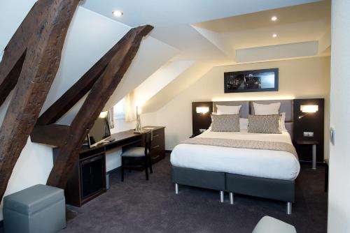 パリにあるホテル ショワズル オペラのベッド、デスク、ベッドが備わるホテルルームです。