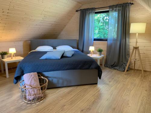 a bedroom with a bed and two tables and a window at Lilla House in Sasino