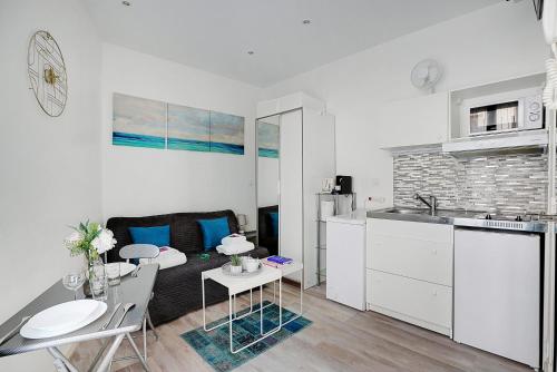 un salon avec un canapé et une table et une cuisine dans l'établissement Comfortable studio - 2P - Grenelle, à Paris