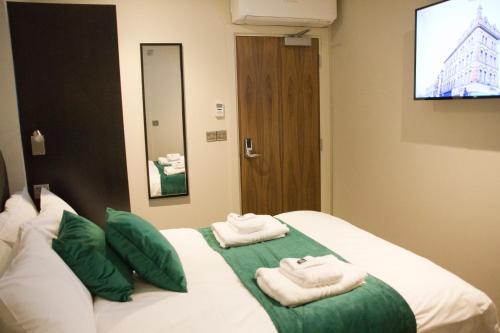 um quarto de hotel com duas toalhas numa cama em Keystone House em Londres