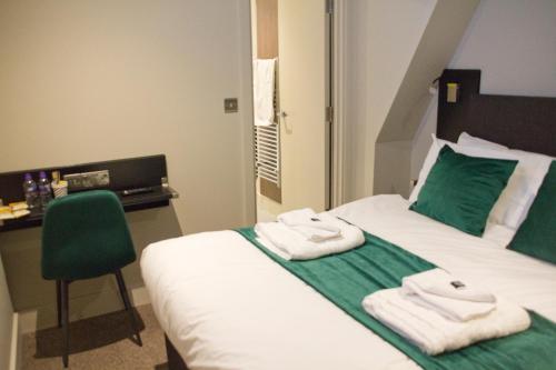 a hotel room with a bed with towels on it at Keystone House in London