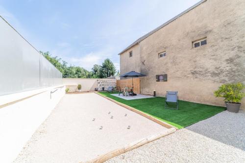 un cortile di un edificio con un cortile di Côté Cour, 3 chambres, terrasses, jardin privé avec terrain de pétanque, cave voutée a Corgoloin