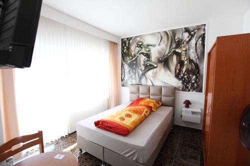 a room with a bed with a painting on the wall at Hotel Sofia in Bad Wildungen