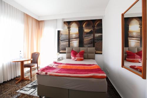 a bedroom with a bed with red pillows on it at Hotel Sofia in Bad Wildungen