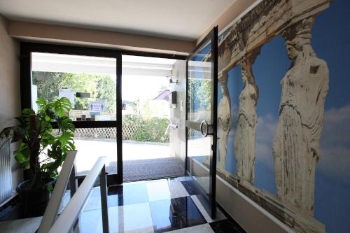 a hallway with a door to a room with a wall with a wall art at Hotel Sofia in Bad Wildungen