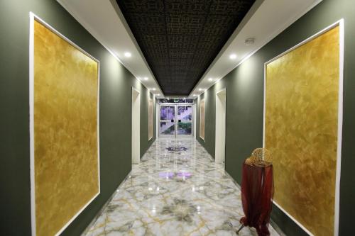 a hallway with a tile floor and a ceiling with paintings at Hotel Sofia in Bad Wildungen