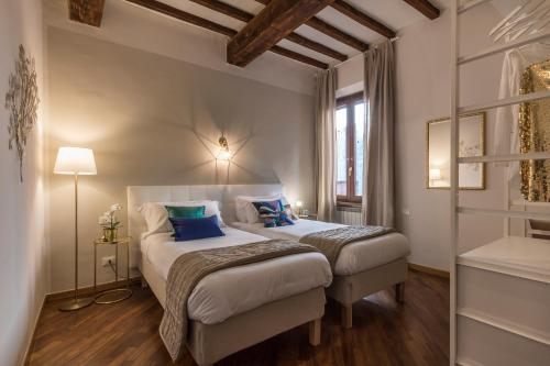 a bedroom with two beds with blue pillows at Casa Dora in Florence