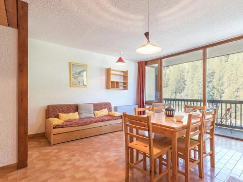 un salon avec une table et un canapé dans l'établissement Appartement familial à Serre-Chevalier : balcon, wifi, parking, à proximité des pistes - FR-1-330E-32, à Saint-Chaffrey