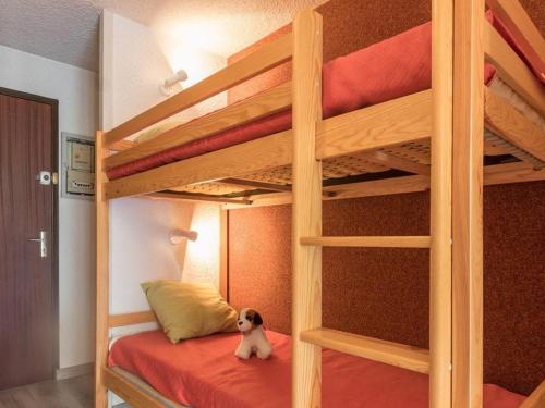 - un petit chien assis sur un lit superposé dans l'établissement Studio lumineux 4 pers., balcon sud, parking - Serre-Chevalier - FR-1-330E-50, à Saint-Chaffrey