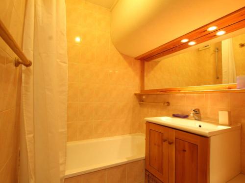 une salle de bain avec un lavabo, une baignoire et un miroir dans l'établissement Studio à Saint-Chaffrey avec casier à ski, garage en option - 4 personnes - FR-1-330E-52, à Saint-Chaffrey