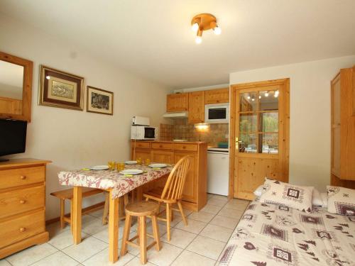 une cuisine avec une table et des chaises ainsi qu'une salle à manger dans l'établissement Studio lumineux avec terrasse sud. Serres-Chevalier, 4 personnes, équipements complets. - FR-1-330E-57, à Saint-Chaffrey