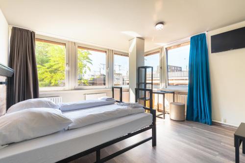 a bedroom with two beds and a large window at a&o Frankfurt Galluswarte in Frankfurt