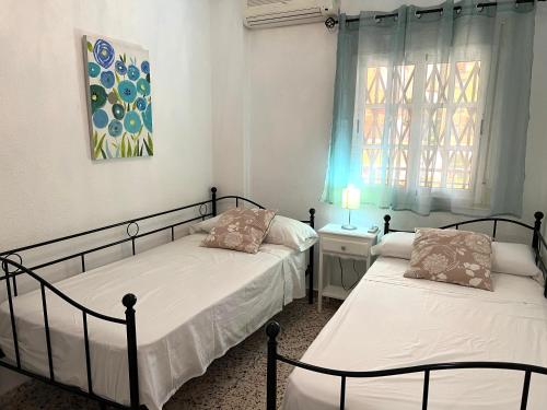 豐希羅拉的住宿－Apartamento Isidoro，一间卧室设有两张床和窗户。