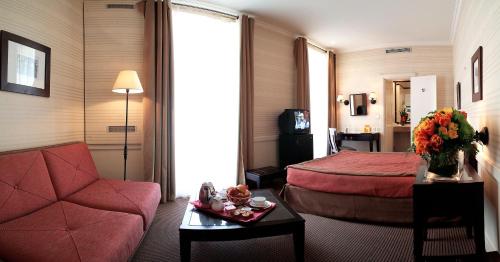 a hotel room with a red bed and a couch at Elysées Union in Paris