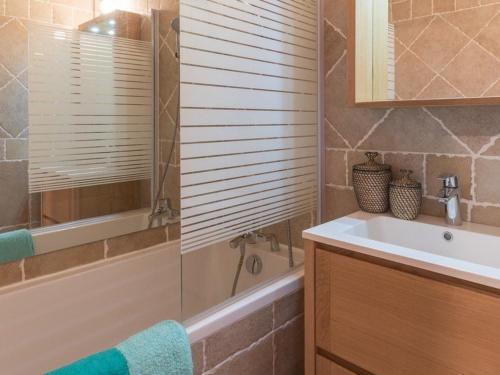 une salle de bain avec un lavabo, une baignoire et un miroir dans l'établissement Studio cosy à Serre-Chevalier - 4 pers, balcon, proche commerces, casier à ski - FR-1-330E-61, à Saint-Chaffrey