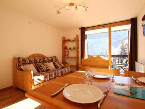 un salon avec une table et un canapé dans l'établissement Studio cosy à Serre-Chevalier - 4 pers, balcon, proche commerces, casier à ski - FR-1-330E-61, à Saint-Chaffrey