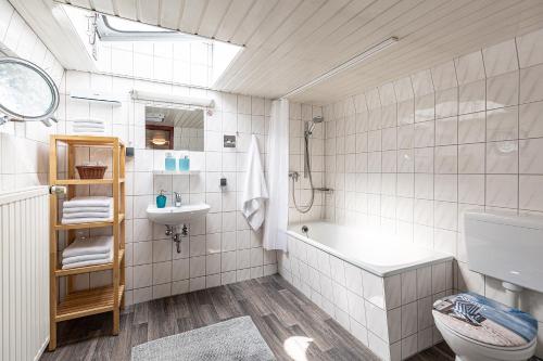 ein Badezimmer mit einer Badewanne, einem WC und einem Waschbecken in der Unterkunft Schiffsherberge Pöppelmann in Dresden
