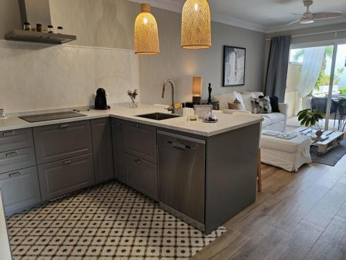 a kitchen with a sink and a living room at Los Órganos Luxe in Puerto de la Cruz