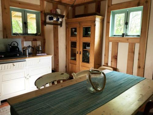 a kitchen with a wooden table with a vase on it at Forest Garden Shovelstrode in East Grinstead