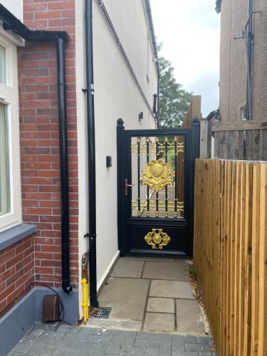 a black gate with a gold crest on it at Phlox Garden in Sutton