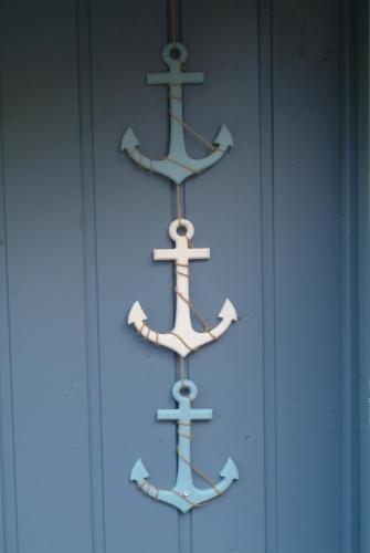 three wooden anchors on a blue building at Hütte Krötenhof, Radfahrer Übernachtung in Barförde