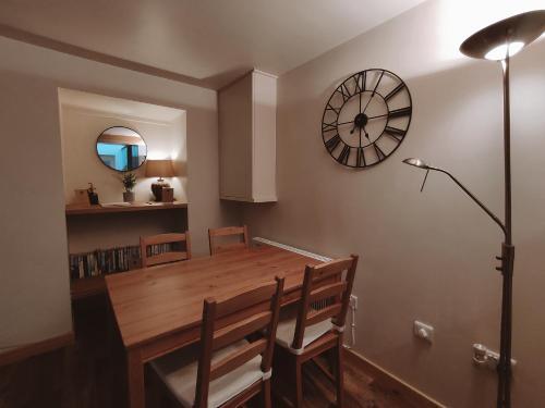 uma sala de jantar com uma mesa e um relógio na parede em The Old Dairy em Brodick