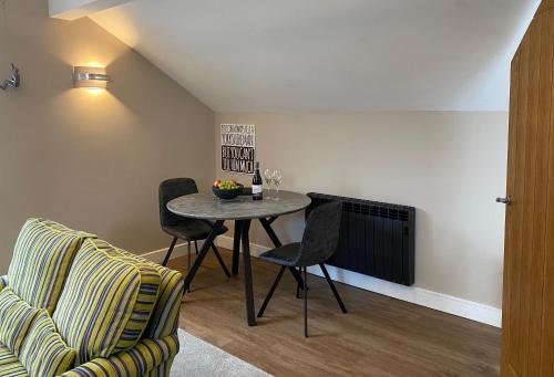 a living room with a table and chairs and a couch at Moll’n’Cliff in Silsden