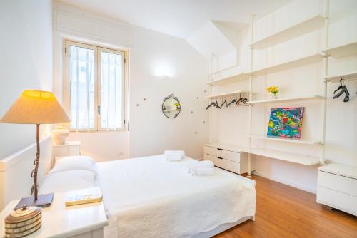 biała sypialnia z łóżkiem i biurkiem w obiekcie Attico Luce e Colori - Terrazza Vista Mare - 5 Bdr w Cagliari