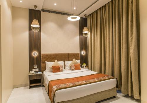 a hotel room with a bed and curtains at The Citi Residenci Hotel - Asansol in Āsansol