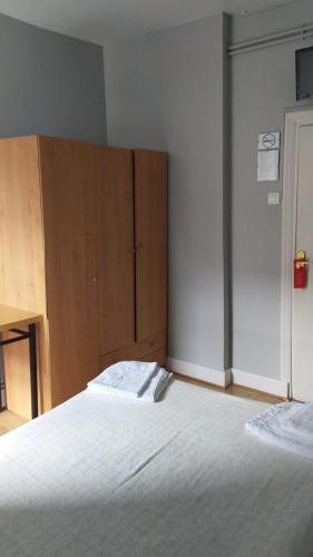 a bedroom with a bed and a wooden cabinet at Pensión Manoli in Bilbao