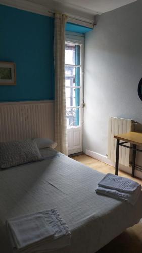 a bedroom with a large bed with a window at Pensión Manoli in Bilbao