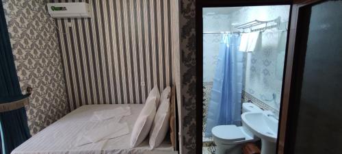 uma casa de banho com uma cama, um WC e um lavatório. em Aminabonu Hotel em Samarcanda