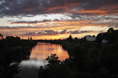 a view of a river with a sunset in the background at Hotel Zum Goldenen Ochsen am Schlossgarten in Aschaffenburg