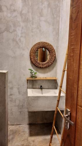 RUMAH @ Sawah Ijen في Licin: حمام مع حوض ومرآة على الحائط