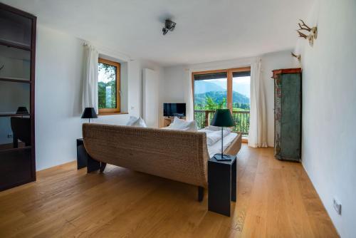 a living room with a couch and a large window at Künstlervilla mit grandiosem Panoramablick in Fischbachau