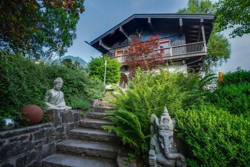 una estatua y escaleras delante de una casa en Künstlervilla mit grandiosem Panoramablick en Fischbachau