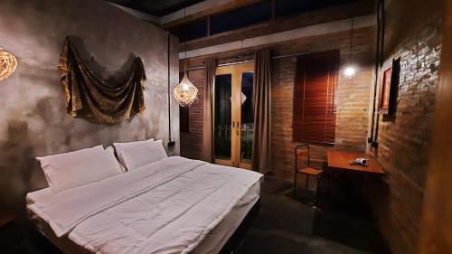 a bedroom with a large bed and a table at RUMAH @ Sawah Ijen in Licin