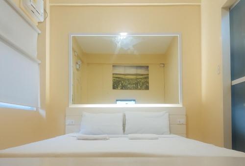 a bedroom with a large mirror above a bed at RedDoorz @ Southern Suites Guimaras in Oracon